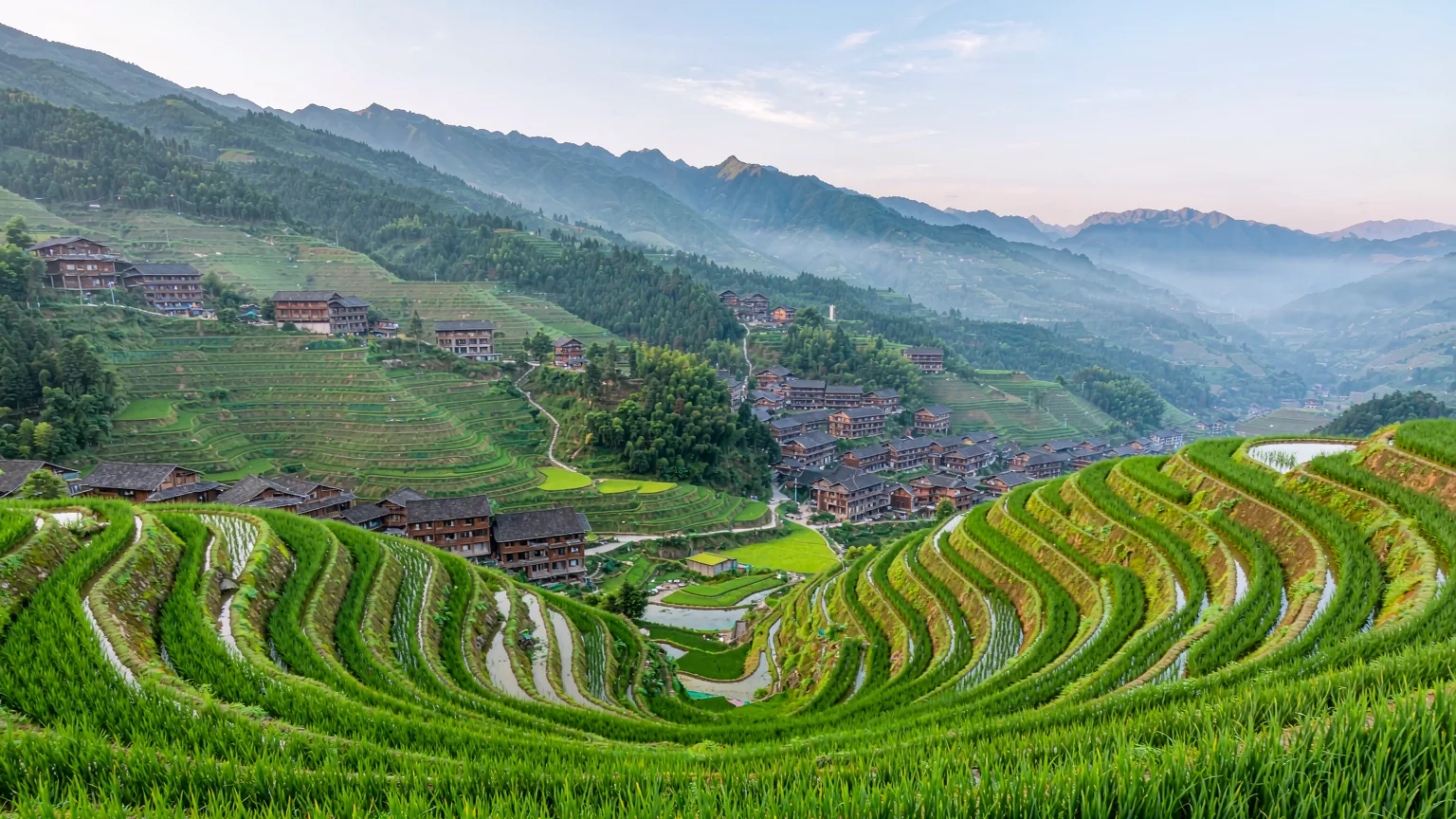 Panoramic view of Longji Rice Terraces with curved paddies and village houses