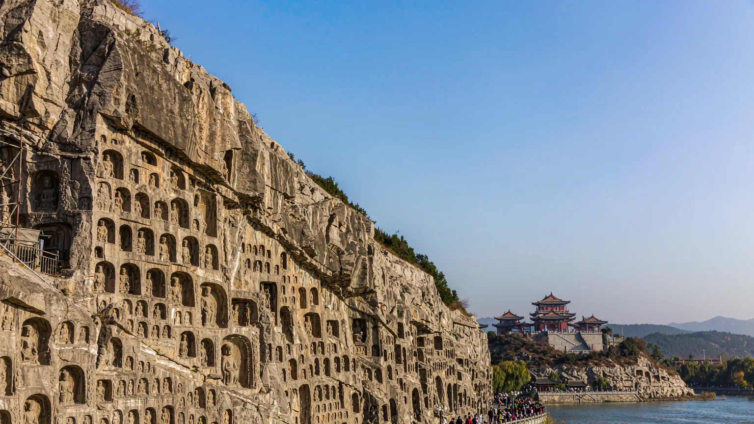 Dense Buddhist carvings on limestone cliffs at Longmen Grottoes