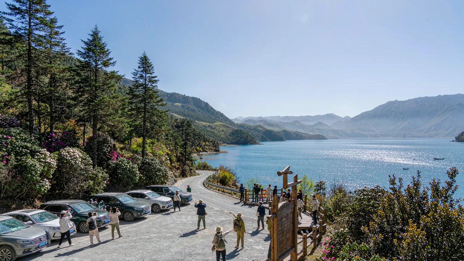 Travelers arriving at Lugu Lake viewpoint via scenic mountain road