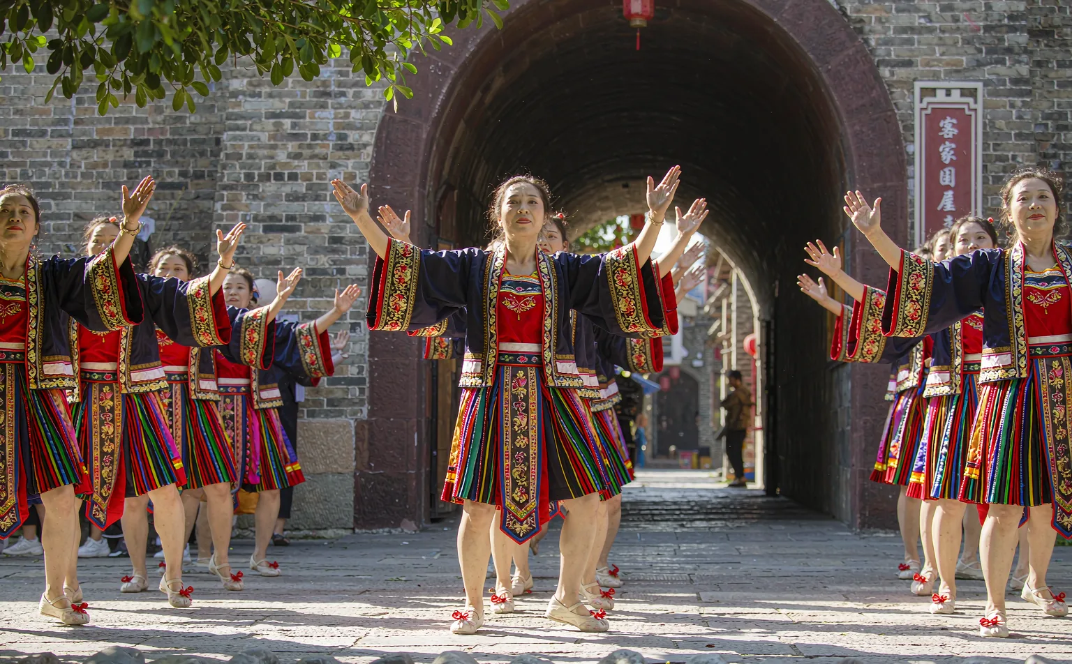 Hakka women in traditional dress performing a folk dance in Luodai