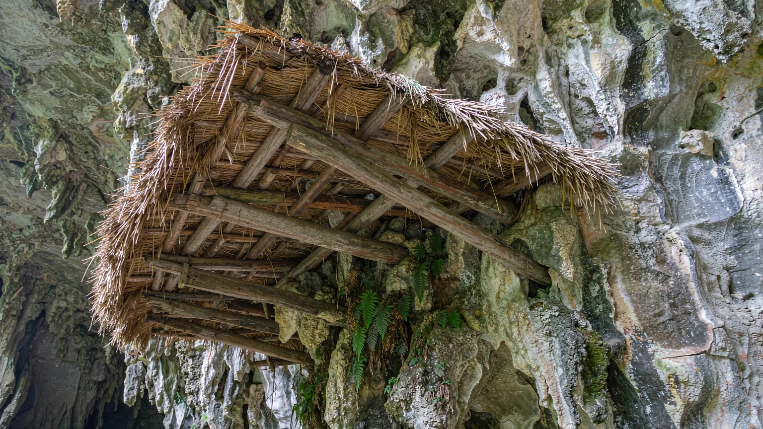 Close-up of a thatched rock overhang used by Tujia boatmen on Maoyan River