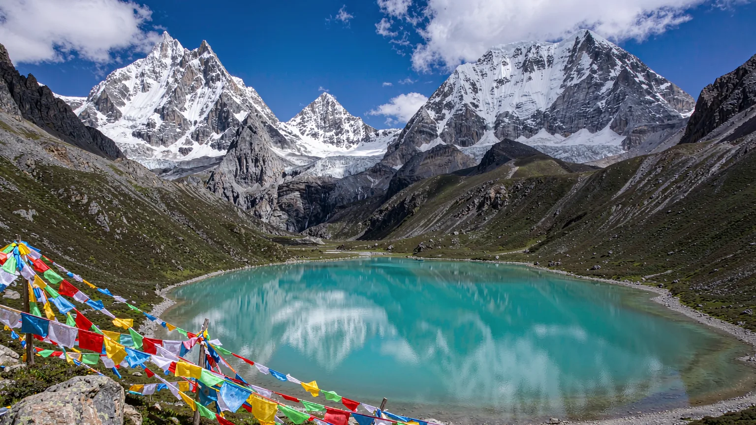 Milky-blue Milk Lake reflecting sacred peaks and prayer flags
