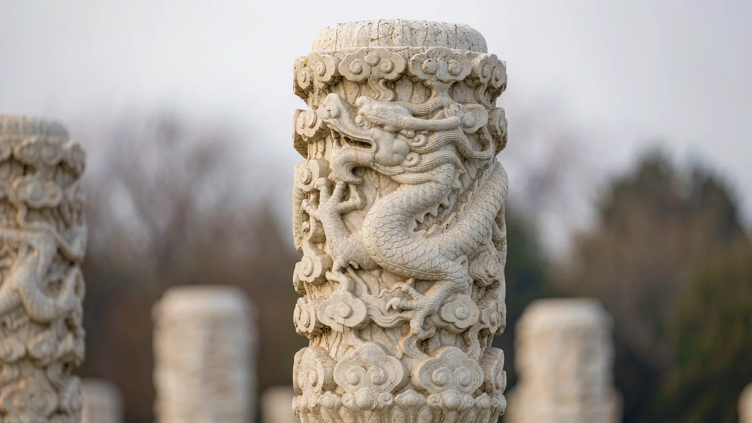 Close-up of intricate dragon carvings on marble pillar at Changling Mausoleum
