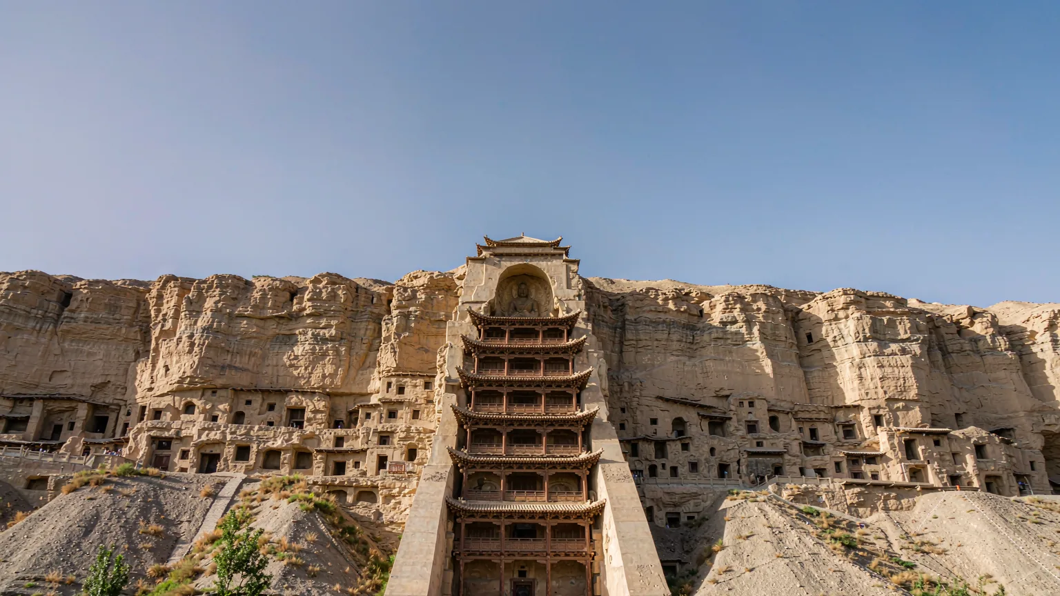 Nine-story Temple facade at Mogao Caves with visitors at base