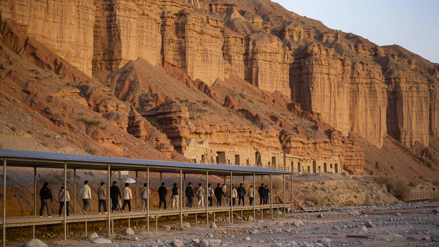 Tour group walking on boardwalk at Mogao Caves with guide