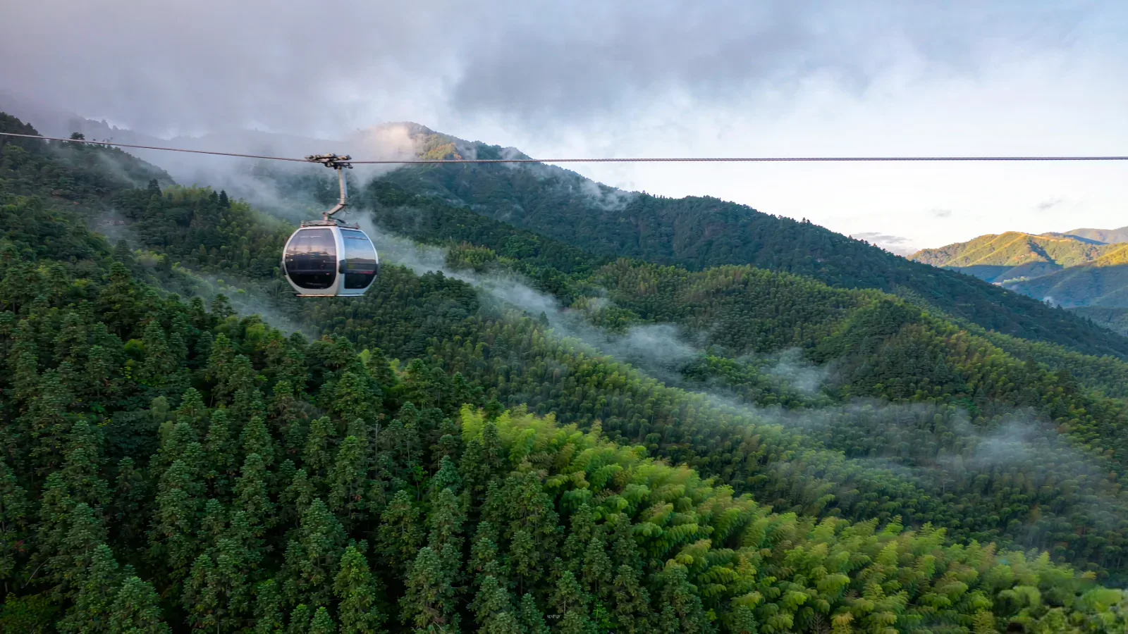 Cable car gliding through the misty forests of Mount Emei