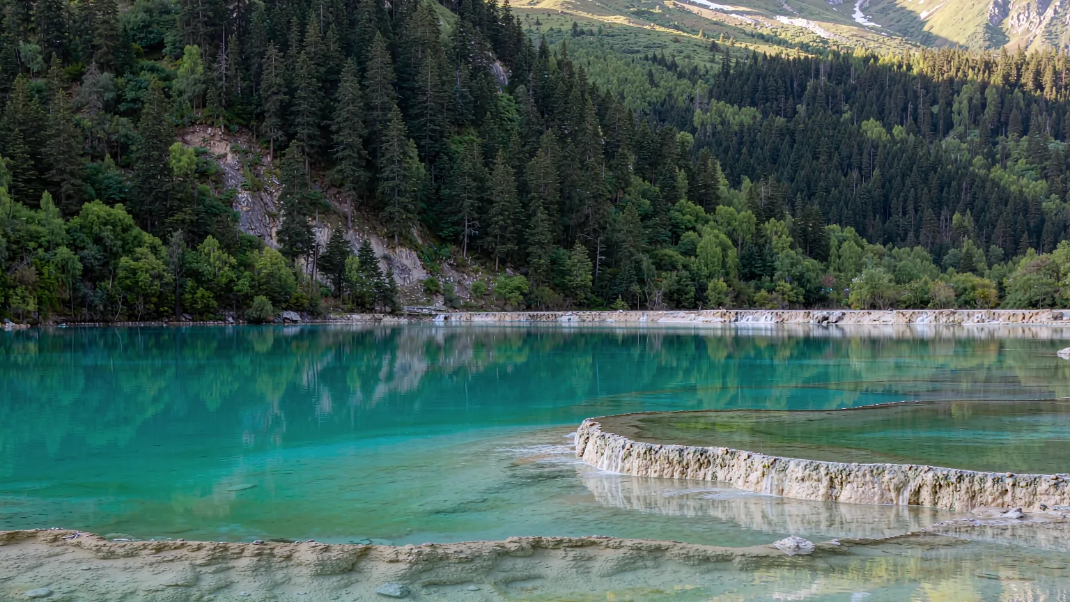Erdao Lake's turquoise water reflecting forested mountains in Munigou Valley
