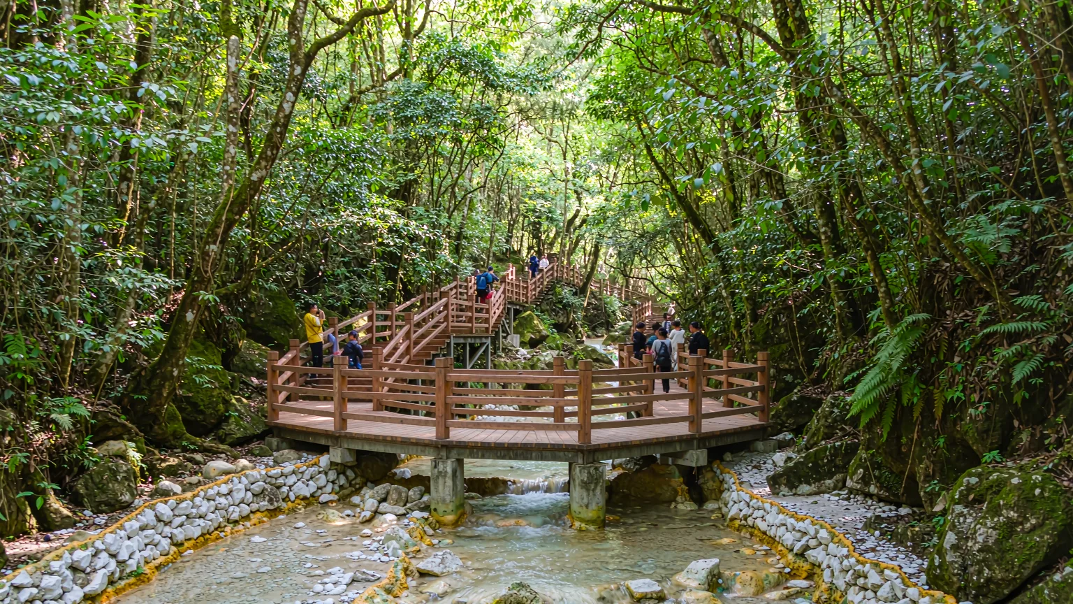Wooden boardwalk through forest leading to Zhaga Waterfall in Munigou Valley