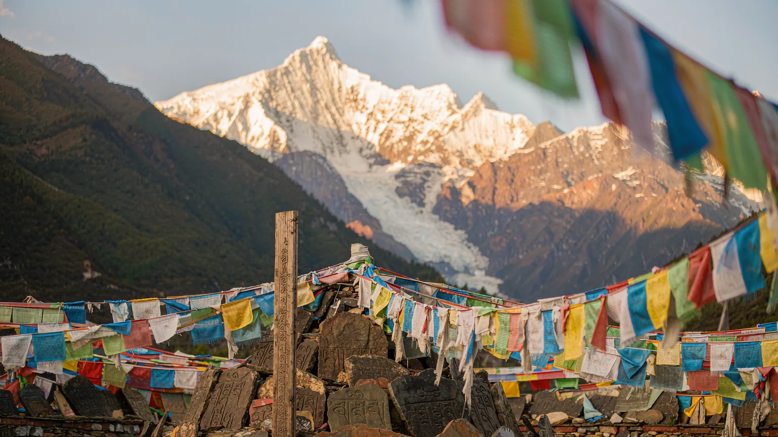 Close-up of mani stones and prayer flags with Namcha Barwa in background