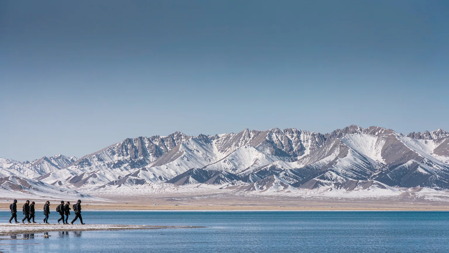 Pilgrims circumambulating the turquoise shores of Namtso Lake in Tibet
