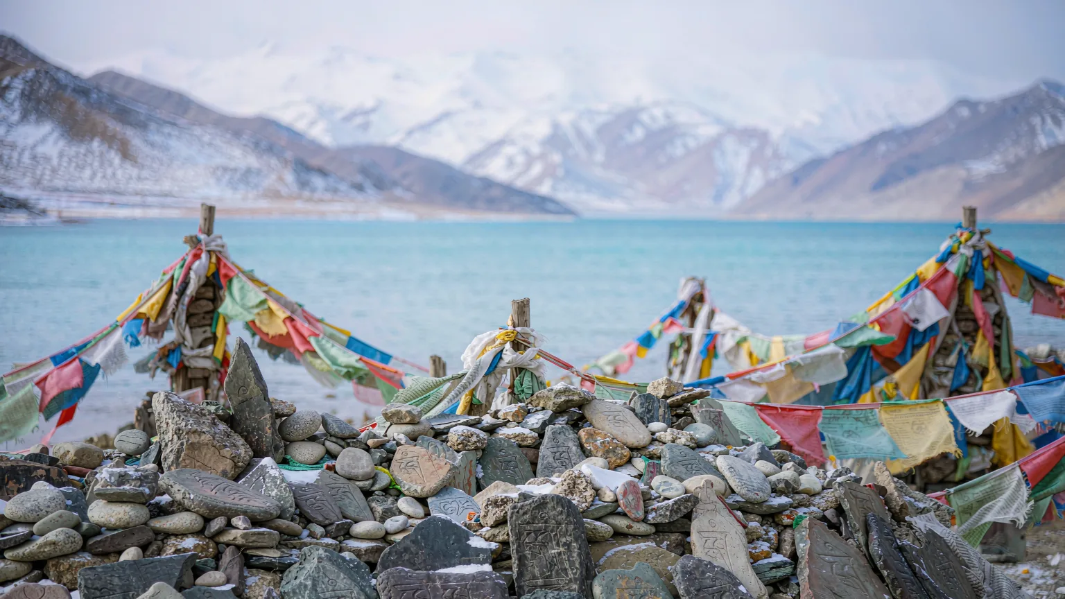 Close-up of carved mani stones and prayer flags by Namtso Lake