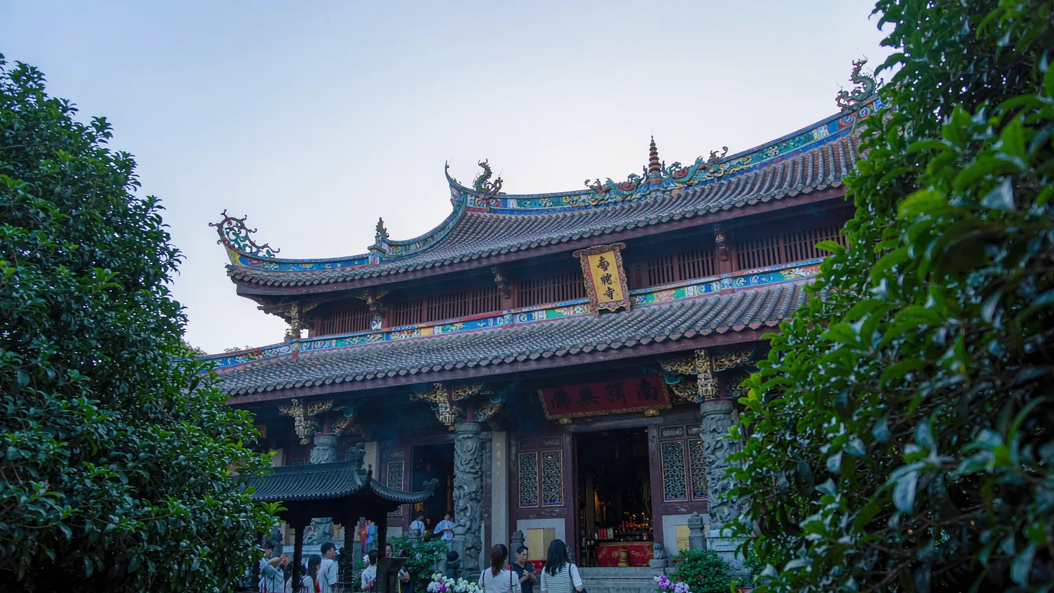 Main shrine hall of Nanputuo Temple with devotees offering incense