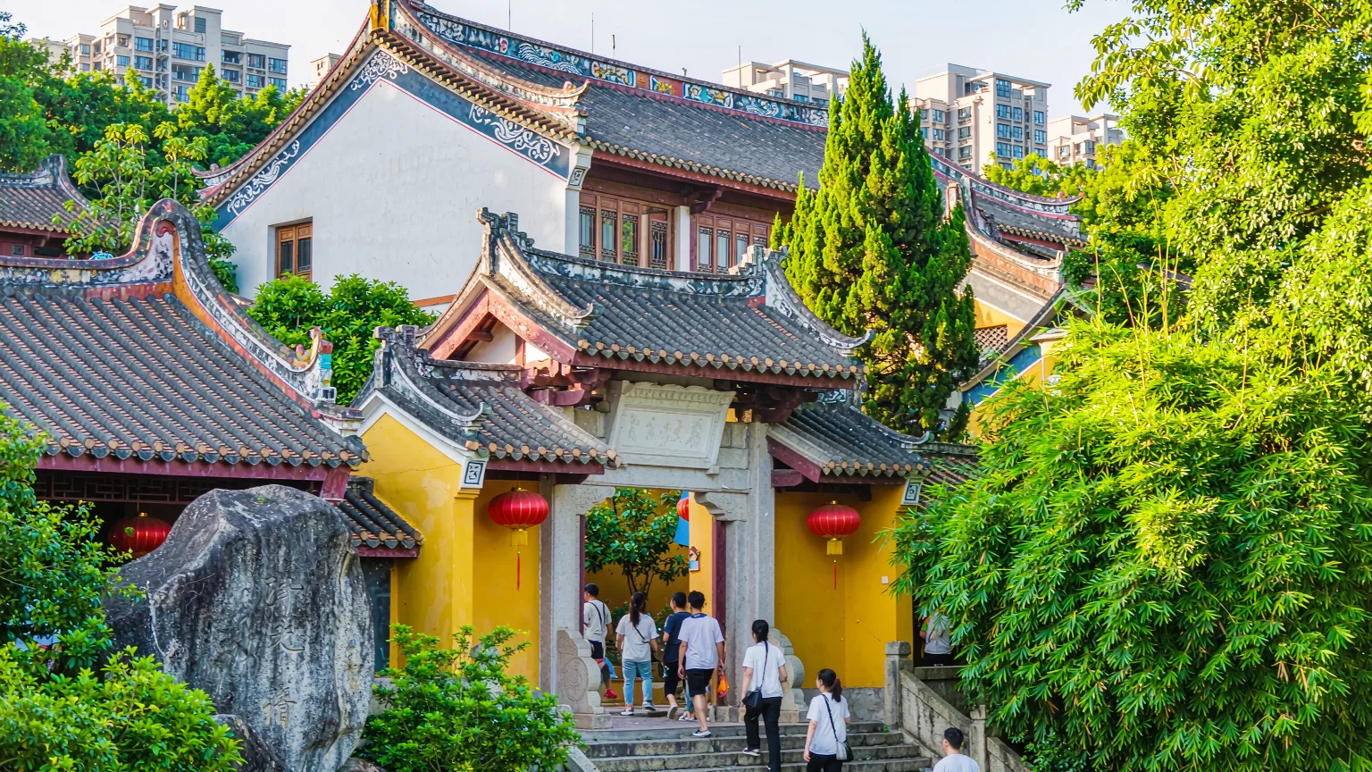 Tourists climbing stone steps to Nanputuo Temple's entrance gate