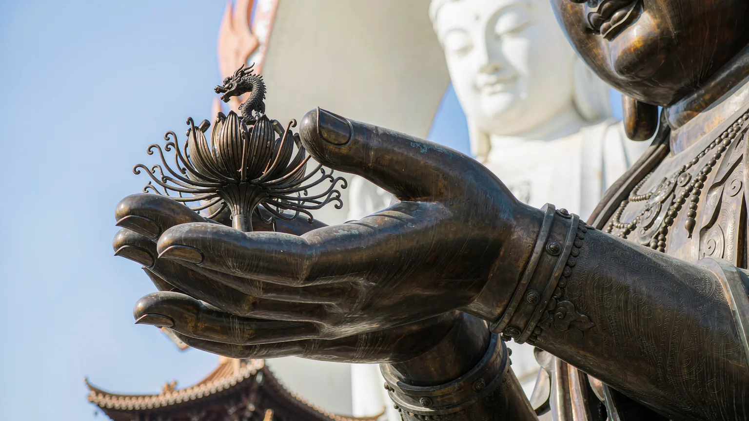 Close-up of Guanyin statue's hand holding a lotus flower