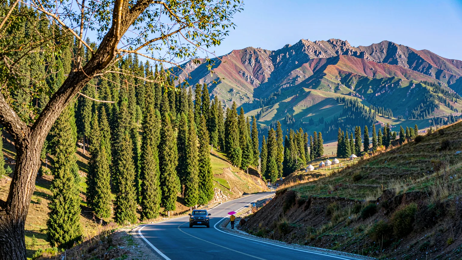 Mountain road winding through Tianshan foothills toward Nanshan Pasture