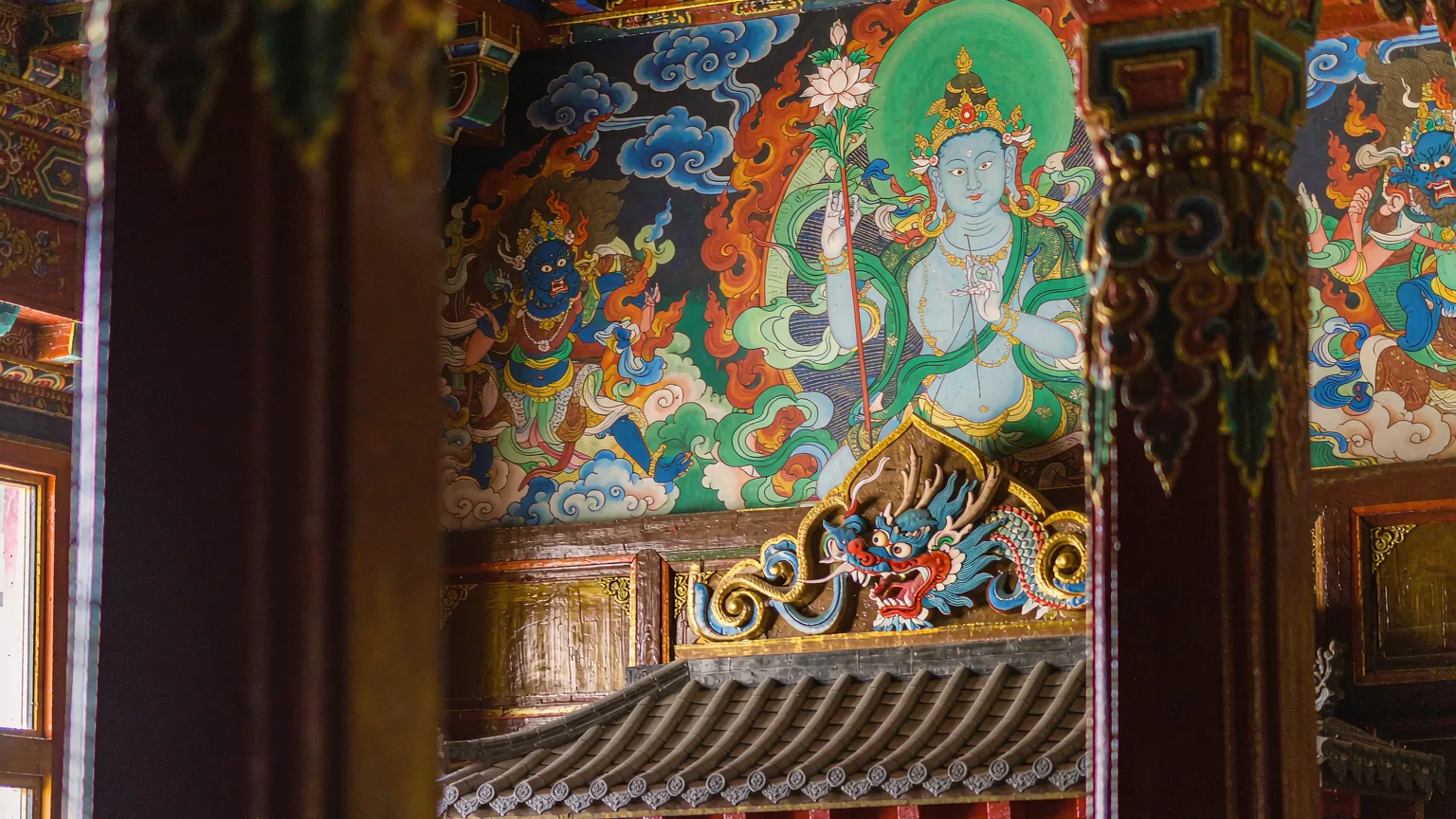 Detailed murals and woodwork inside Norbulingka chapel
