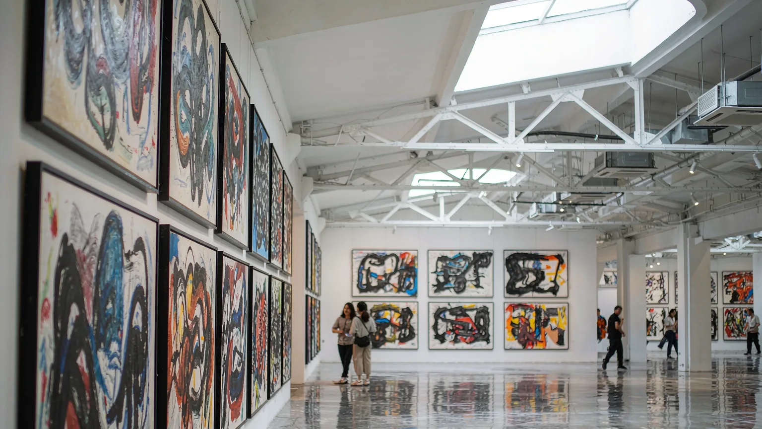 Contemporary art gallery interior in OCT Loft with abstract paintings and industrial ceiling