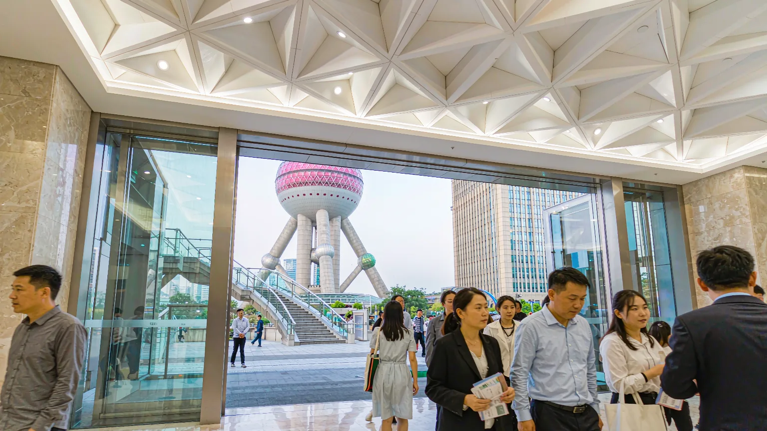 Tourists entering the Oriental Pearl Tower lobby with guide and tickets