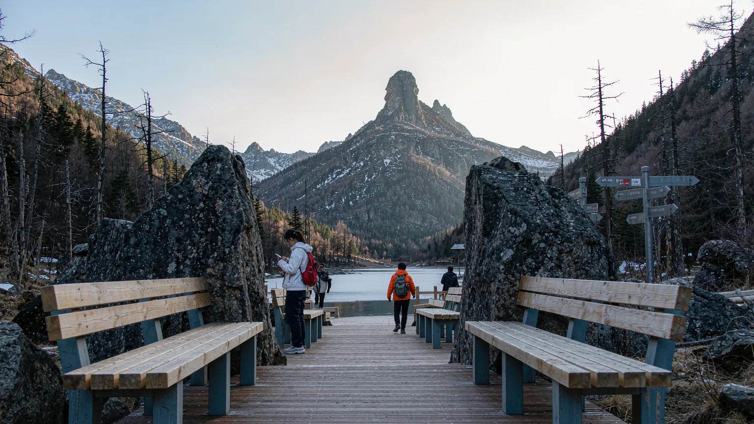 Wooden boardwalk leading to Pearl Lake with hikers and mountain backdrop