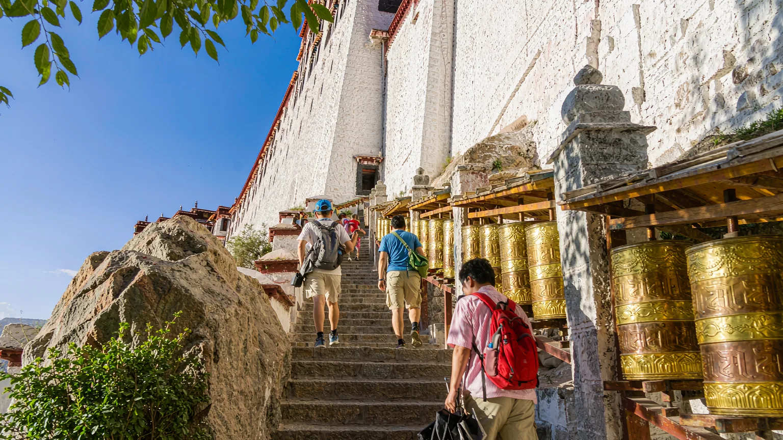 Tourists climbing stone steps to Potala Palace entrance