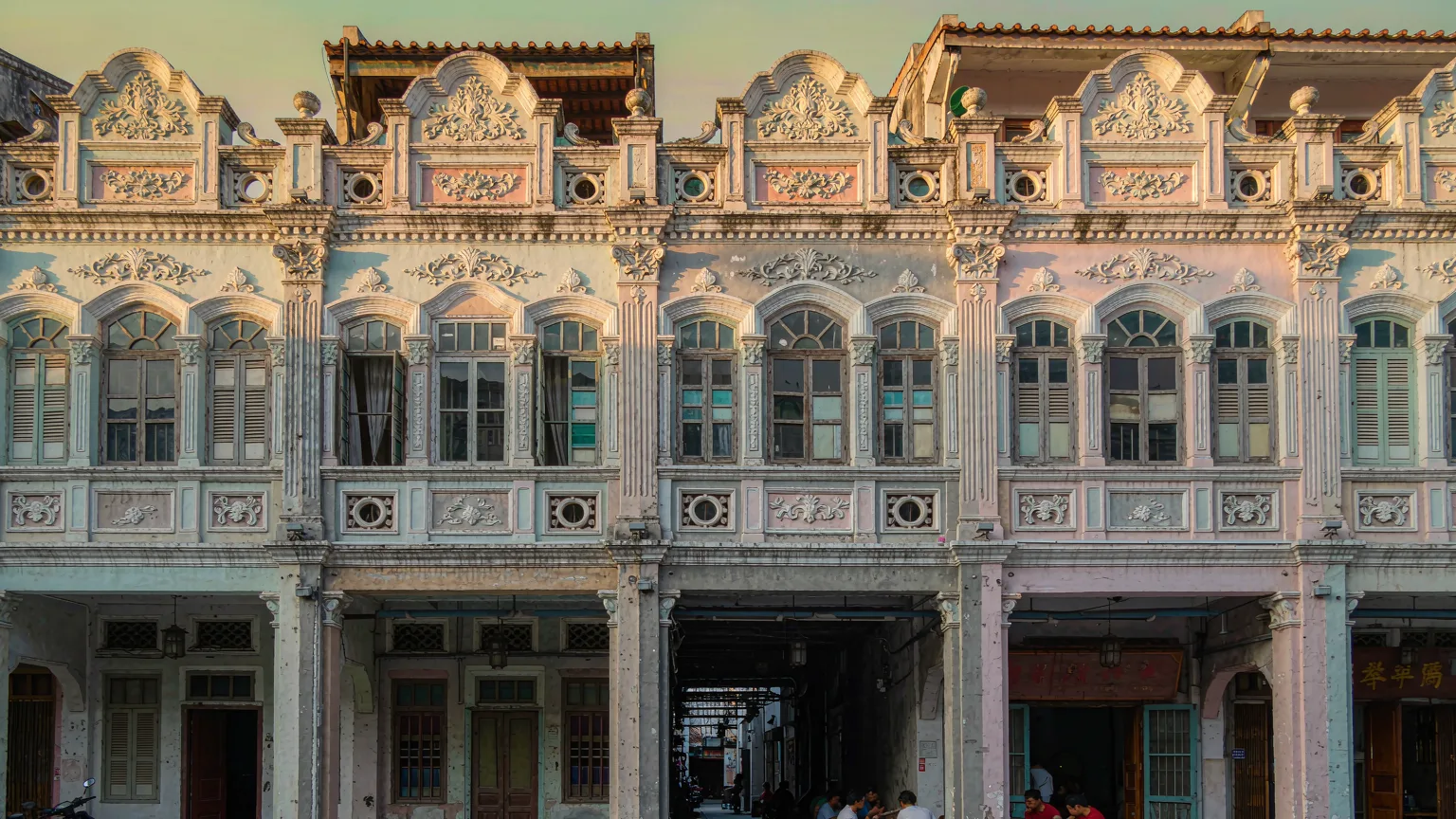 Detailed facades of Qilou shophouses with arcades and locals