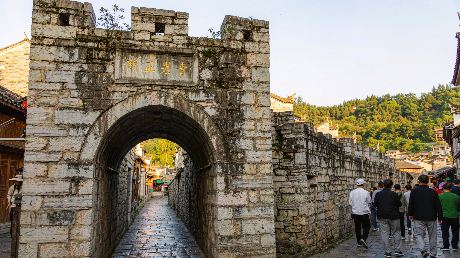 Tourists entering Qingyan Ancient Town through its ancient stone gate