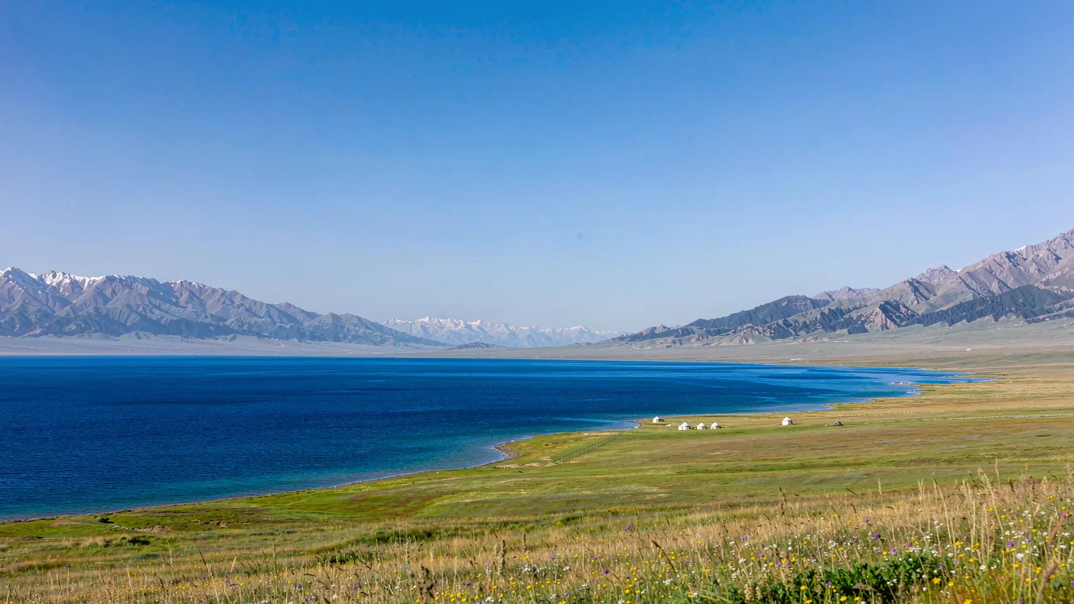 Panoramic view of Sayram Lake with mountains and meadows