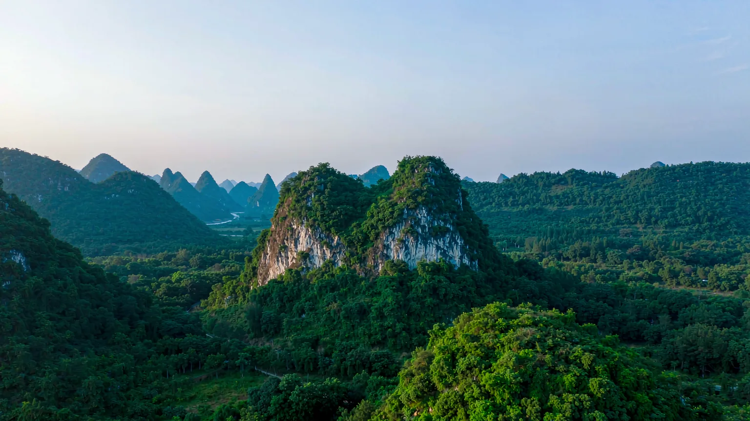 Camel Hill's twin limestone peaks rising above lush greenery in Seven Star Park