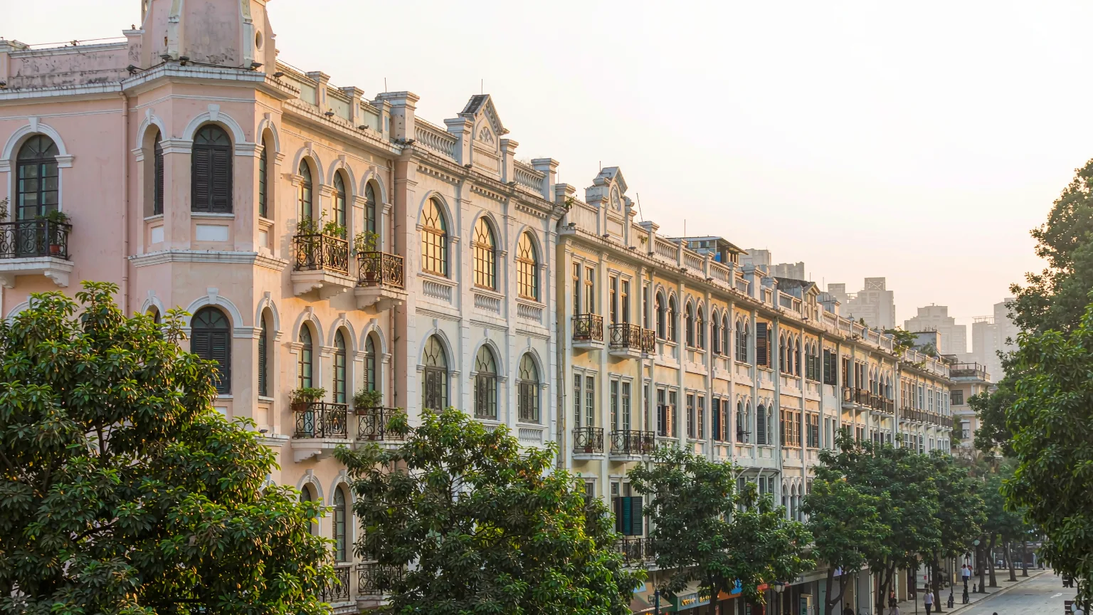 Quiet avenue on Shamian Island with pastel colonial buildings and trees