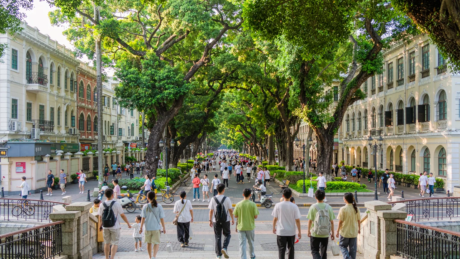 People walking across the bridge entrance to Shamian Island