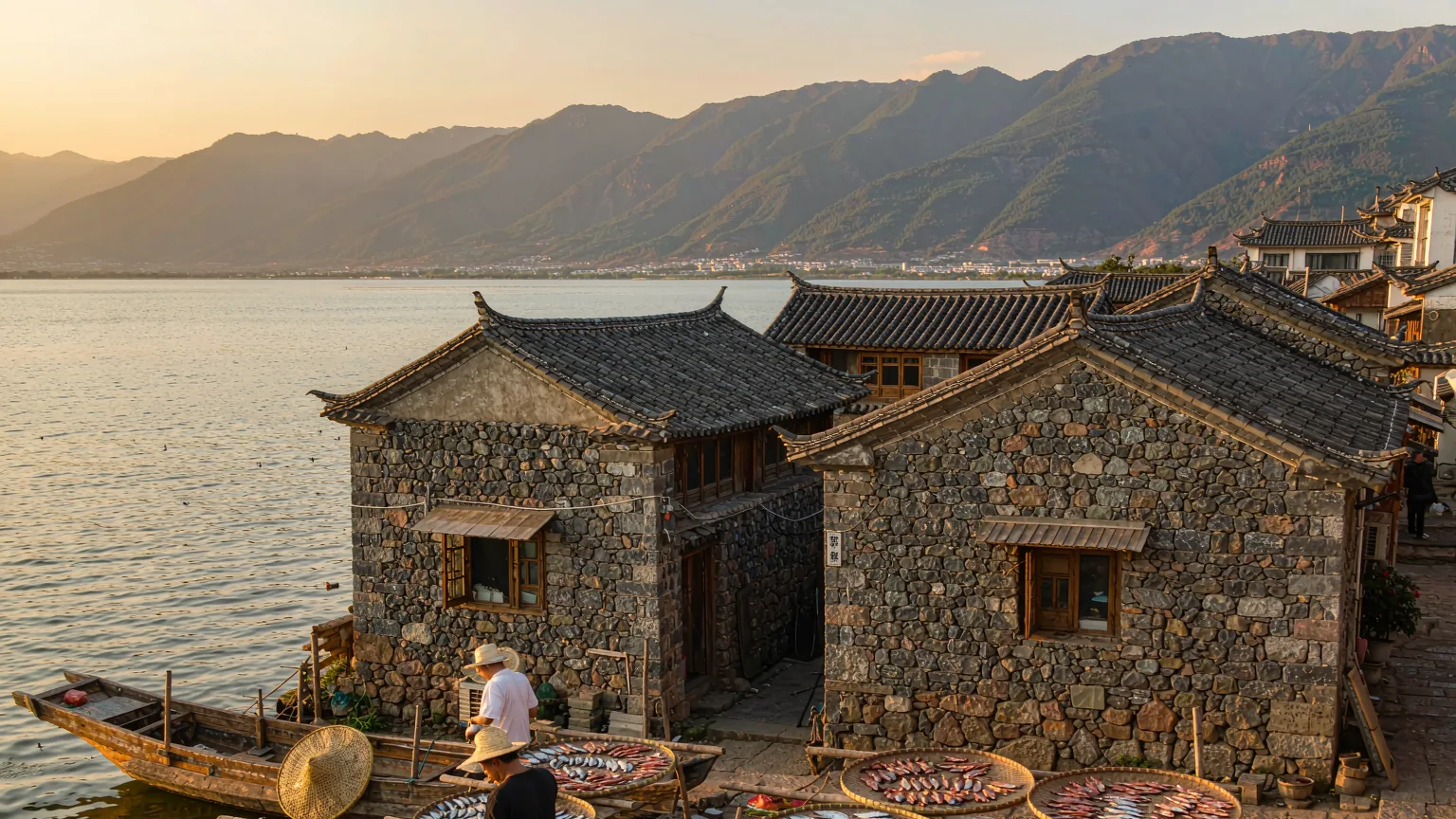 Bai fishermen drying fish on the lakeside of Shuanglang Ancient Town with traditional houses