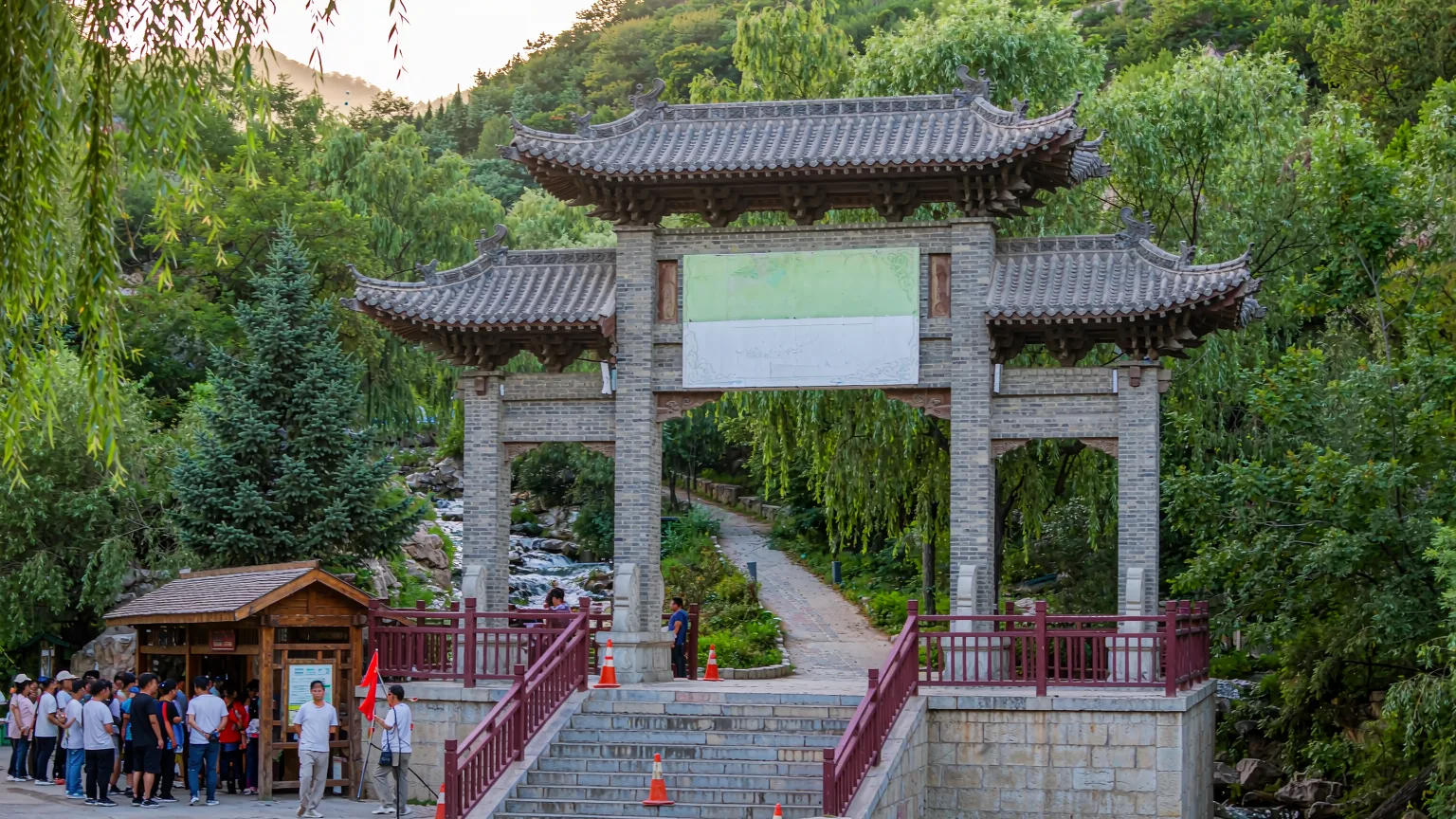 Entrance gate of Shuimogou Scenic Area with visitors and guide