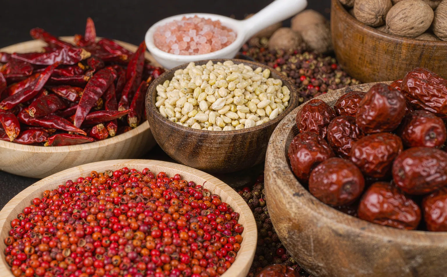 Sichuan pepper and spices displayed in wooden bowls