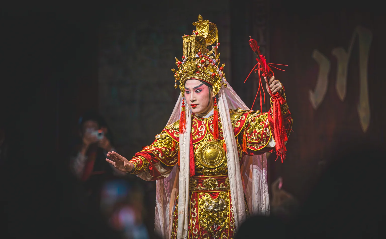 Sichuan opera performer in ornate costume and golden headdress on stage
