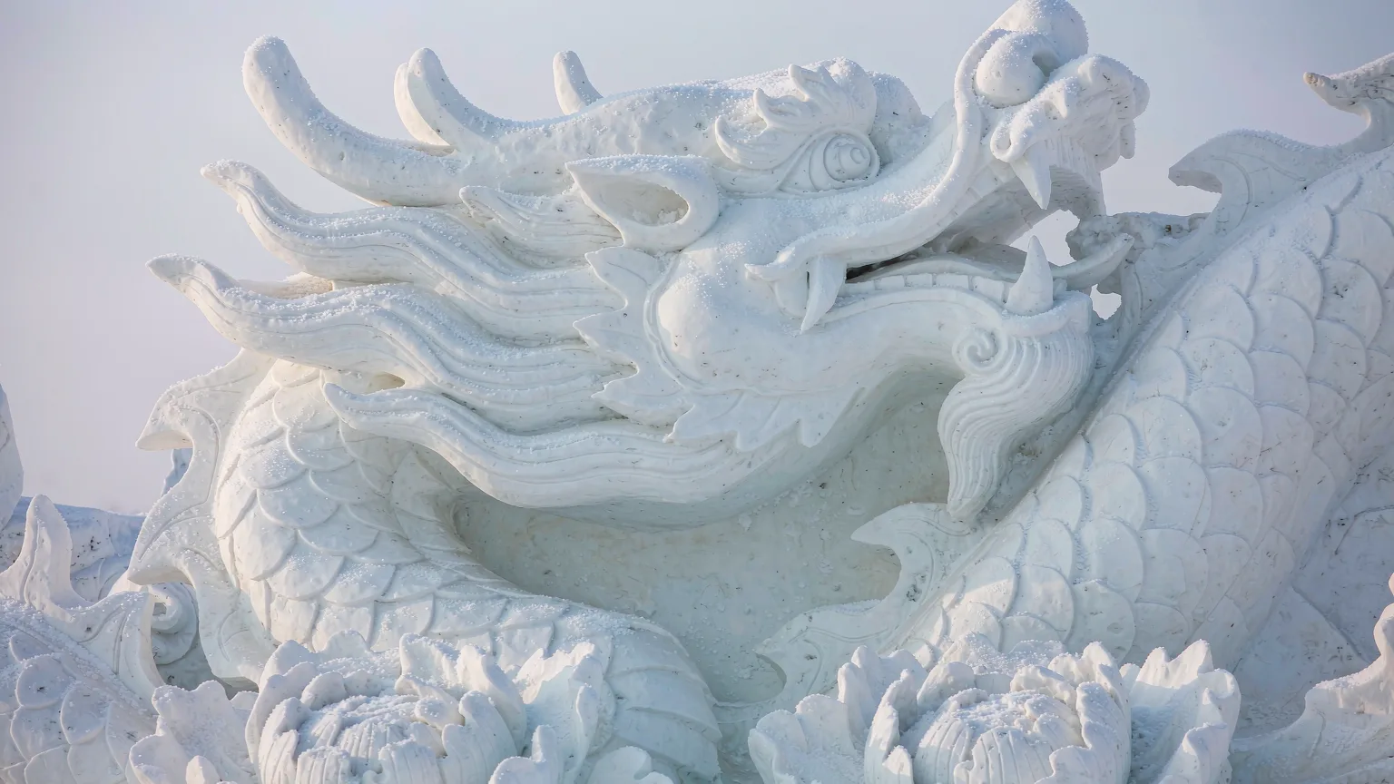 Detailed snow sculpture with carved dragon and floral patterns