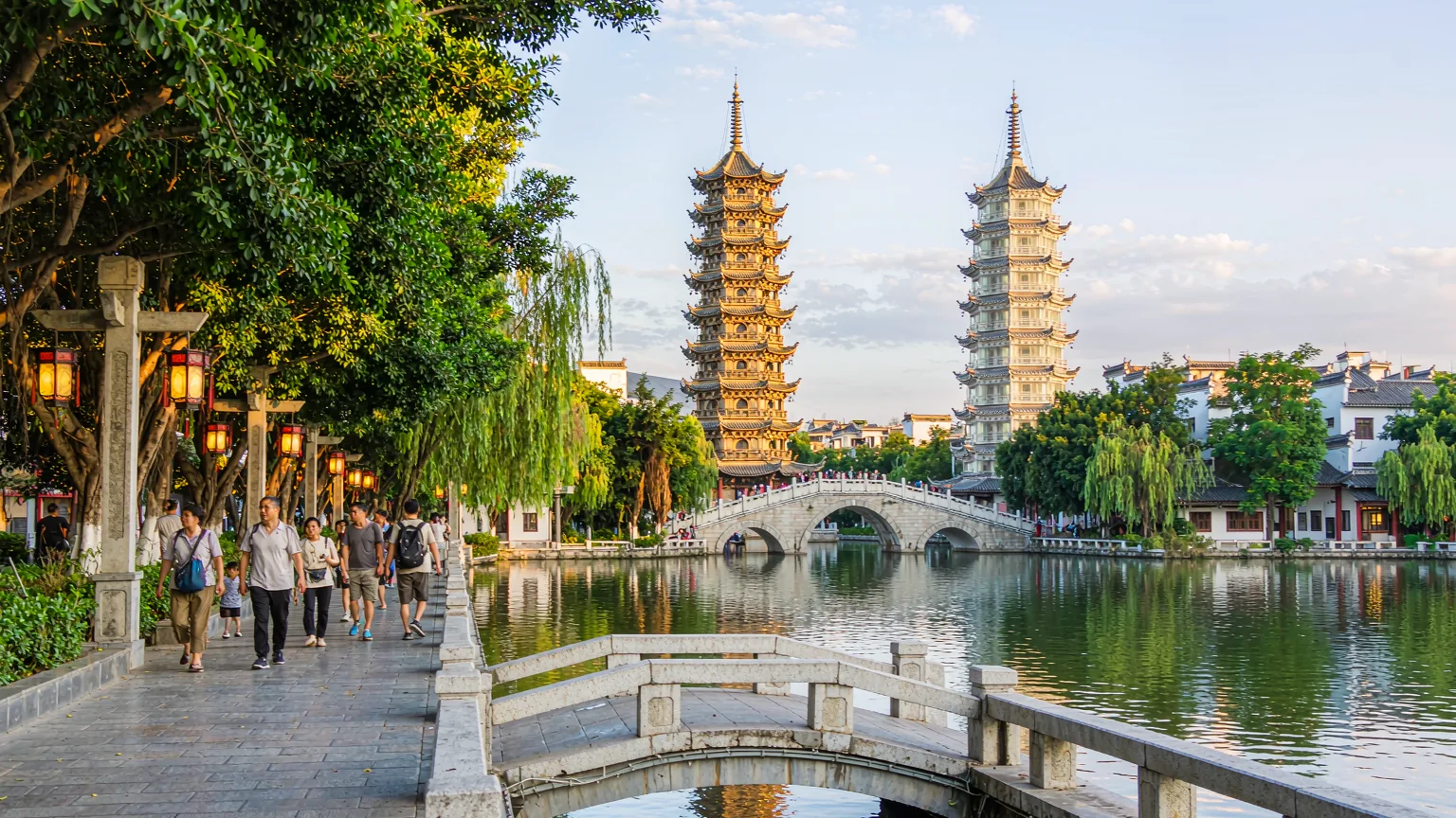 Visitors strolling lakeside path toward the Twin Pagodas in Guilin
