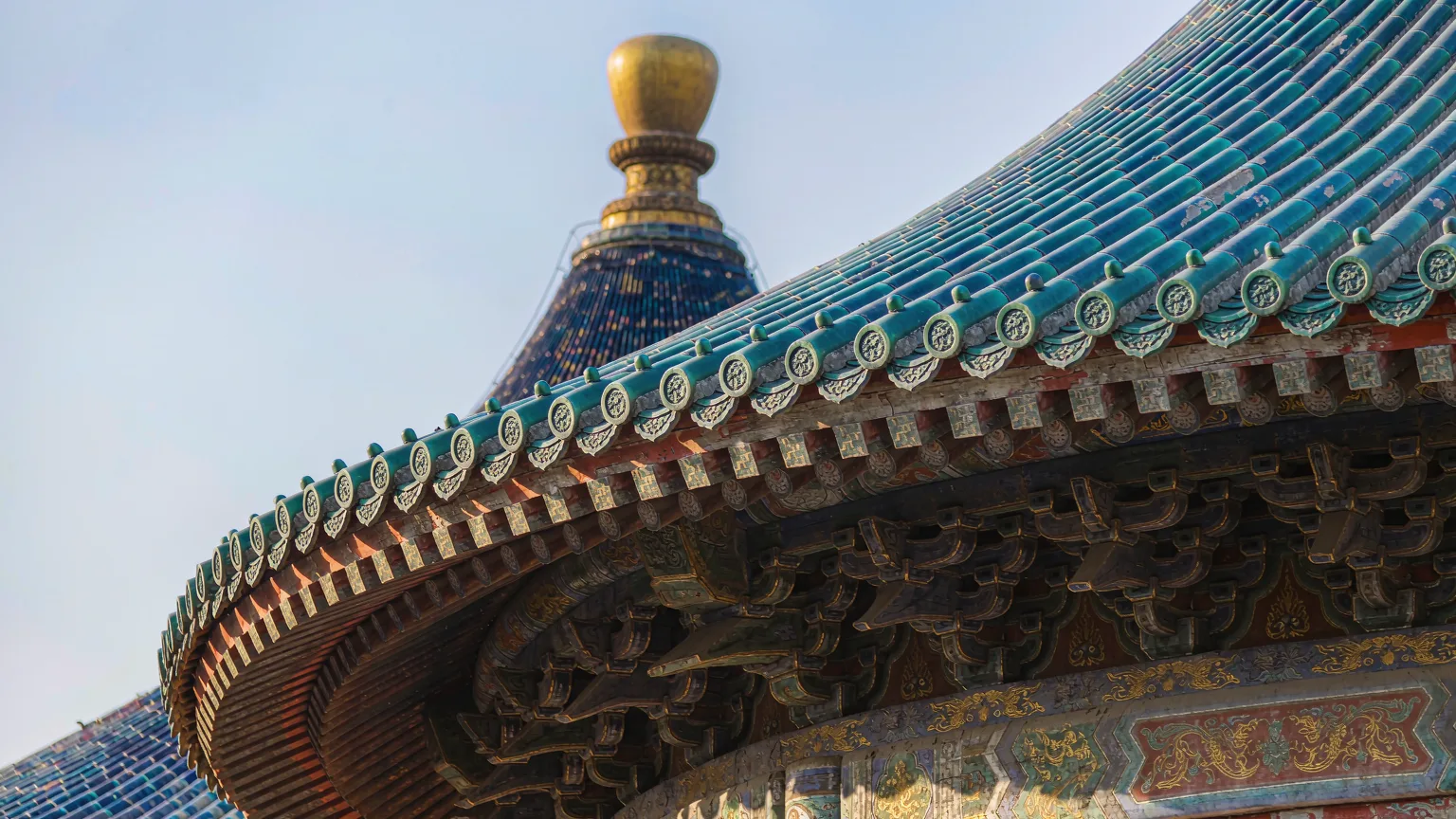 Close-up of blue glazed roof tiles and golden finial