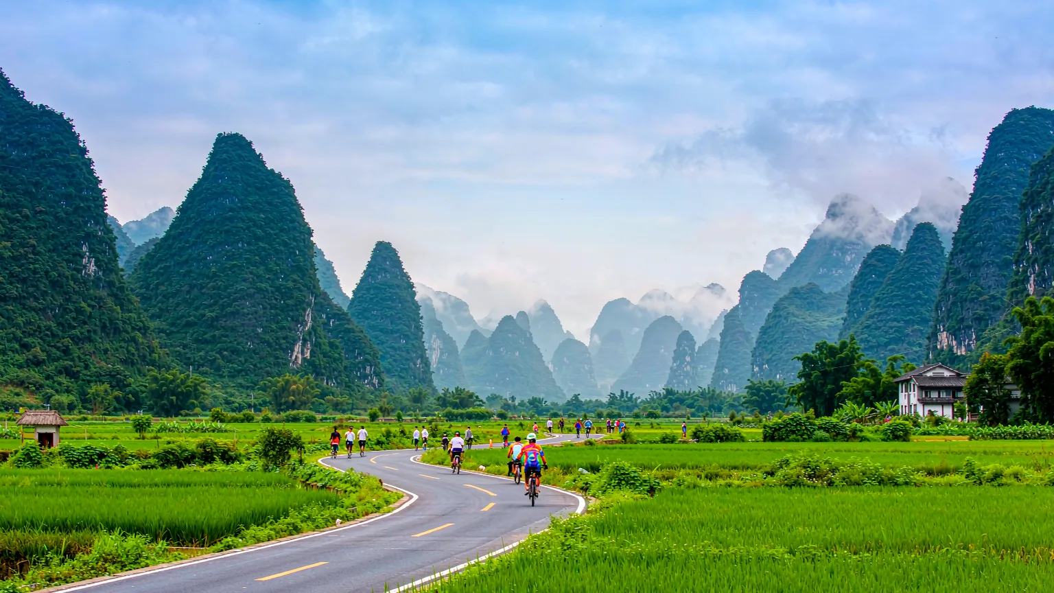 Country road through Ten-Mile Gallery with cyclists and karst mountains