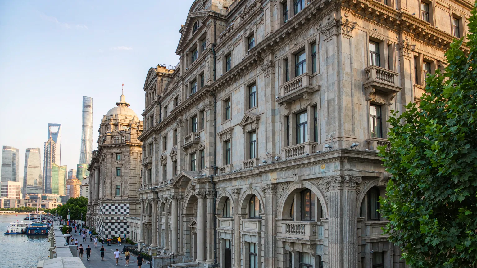 Colonial buildings along the Bund promenade with Pudong skyline in background