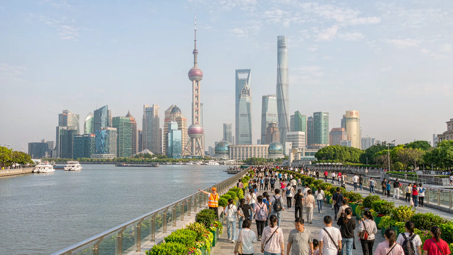 People strolling on the Bund promenade with river and skyline views