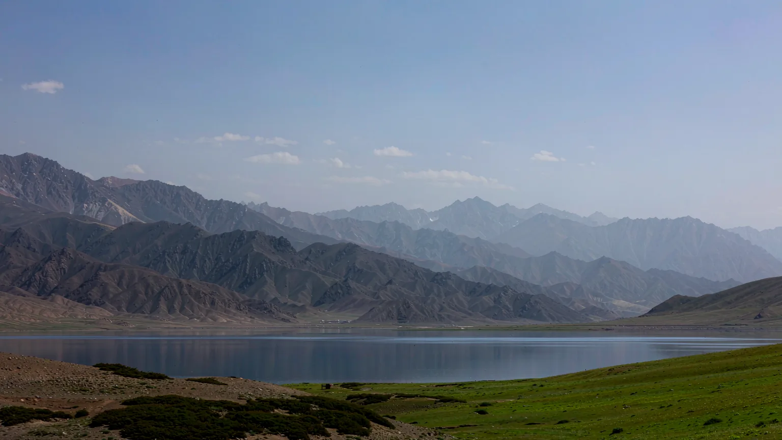 Panoramic alpine view of Tianchi Lake ringed by spruce forest in Tianshan