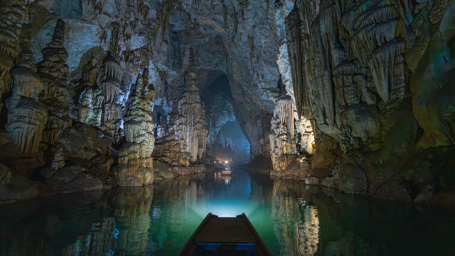 Boat tour inside Tianhetan's illuminated cave with stalactites