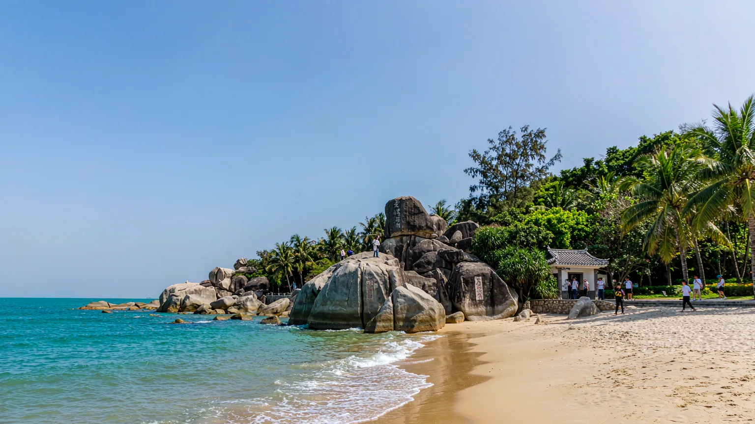 Tianya Haijiao coastal park with inscribed boulders, sandy beach, and turquoise sea