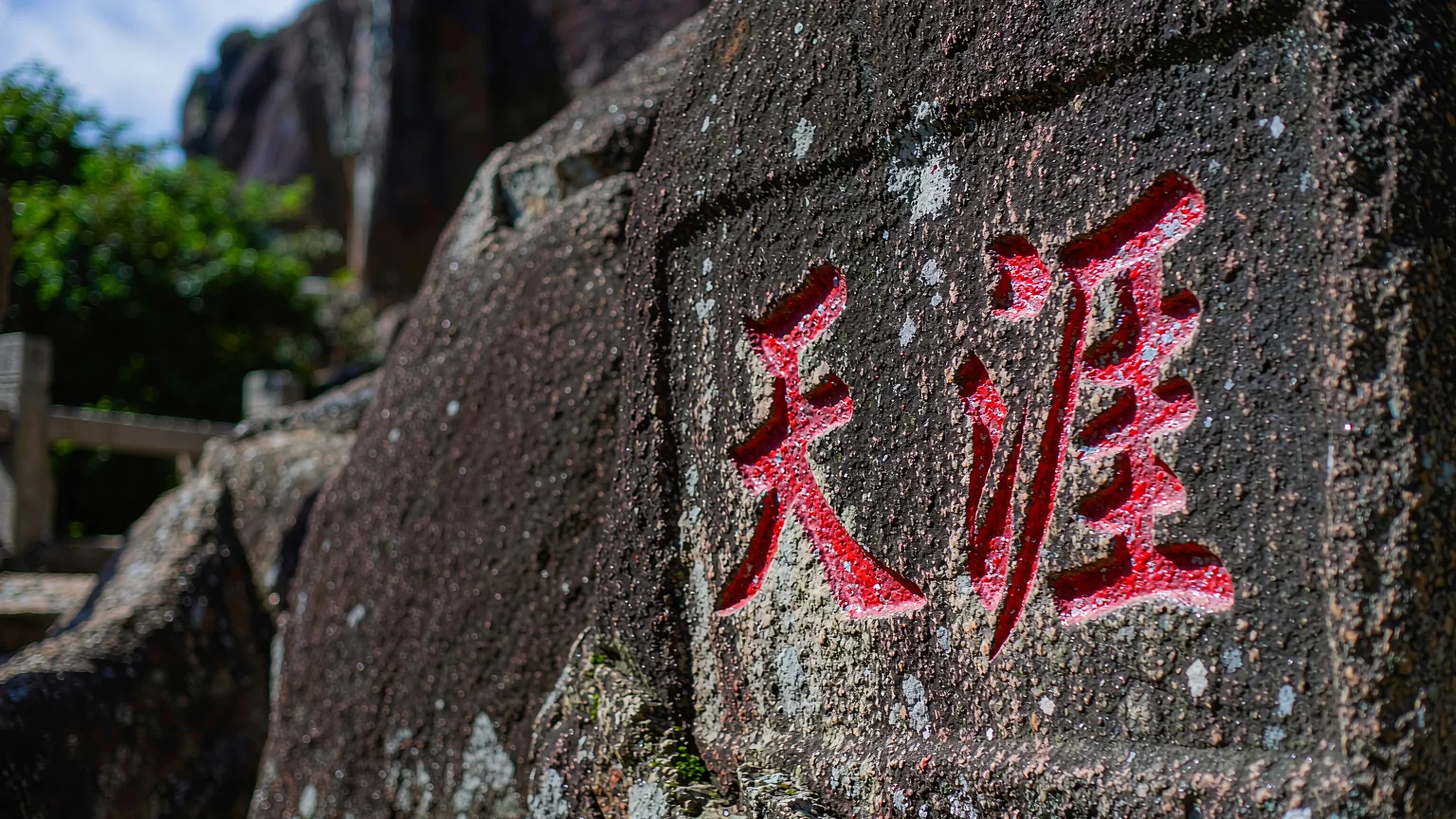 Close-up of '天涯' characters carved into a weathered boulder at Tianya Haijiao