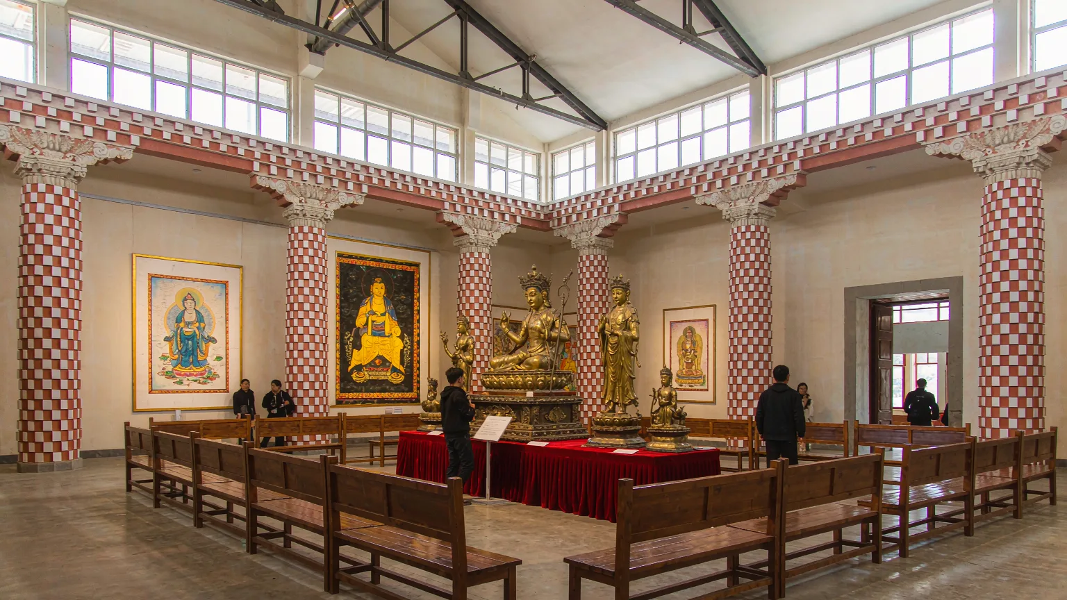 Visitors viewing thangkas and statues inside Tibet Museum gallery