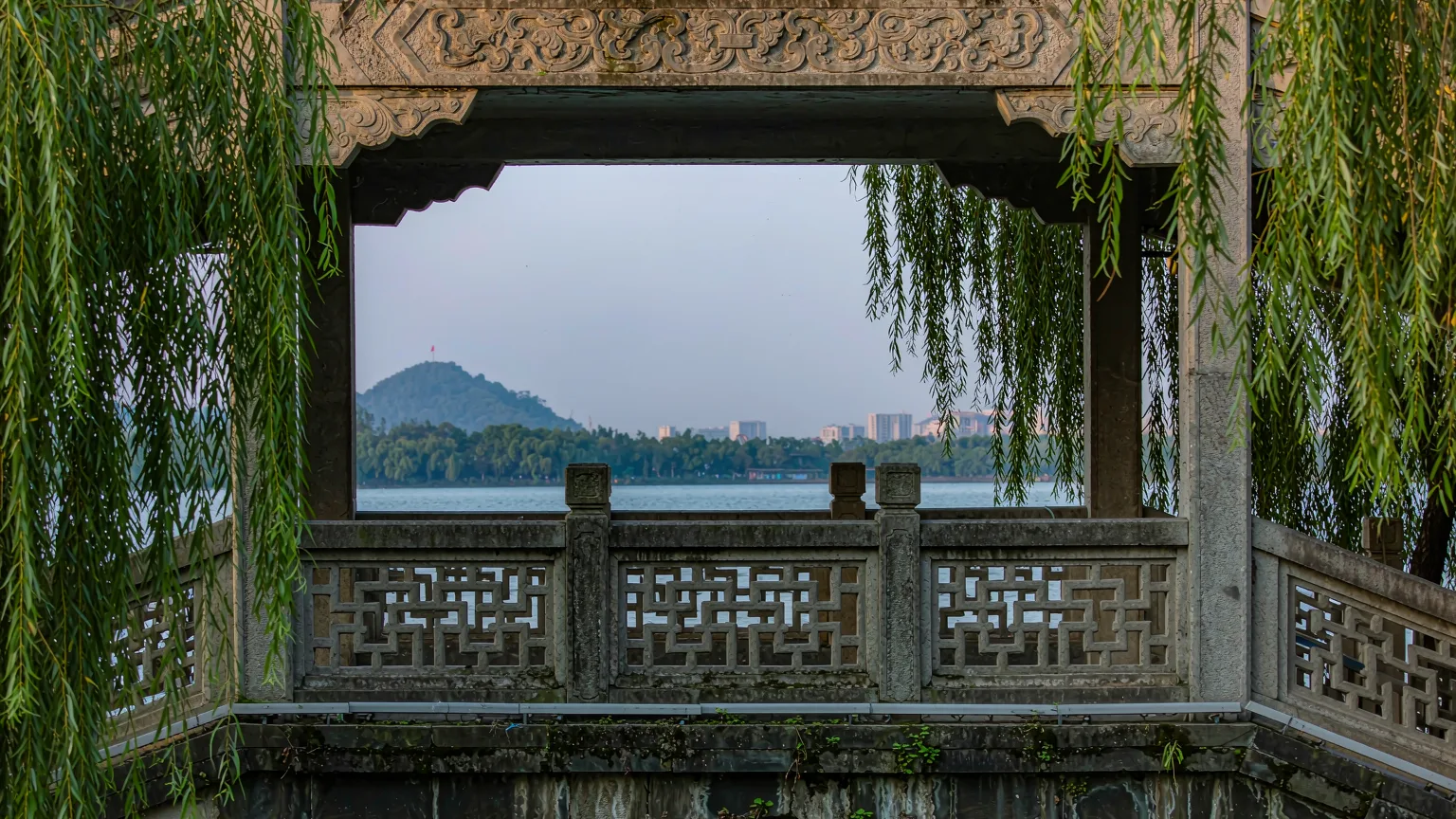 Detailed stone bridge arch with carvings over calm water in Guilin