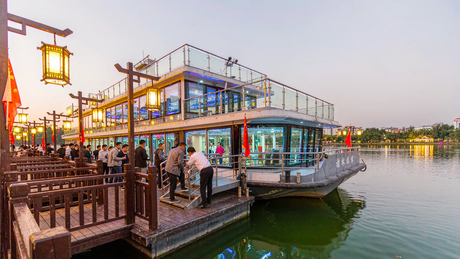 Visitors boarding a tour boat at a lantern-lit pier on Guilin's lakes