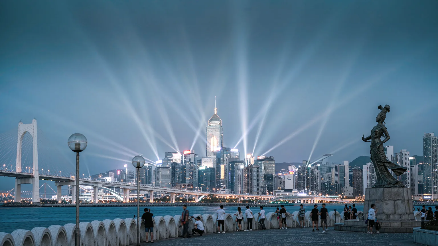 Visitors on Tsim Sha Tsui promenade watching Victoria Harbour at dusk