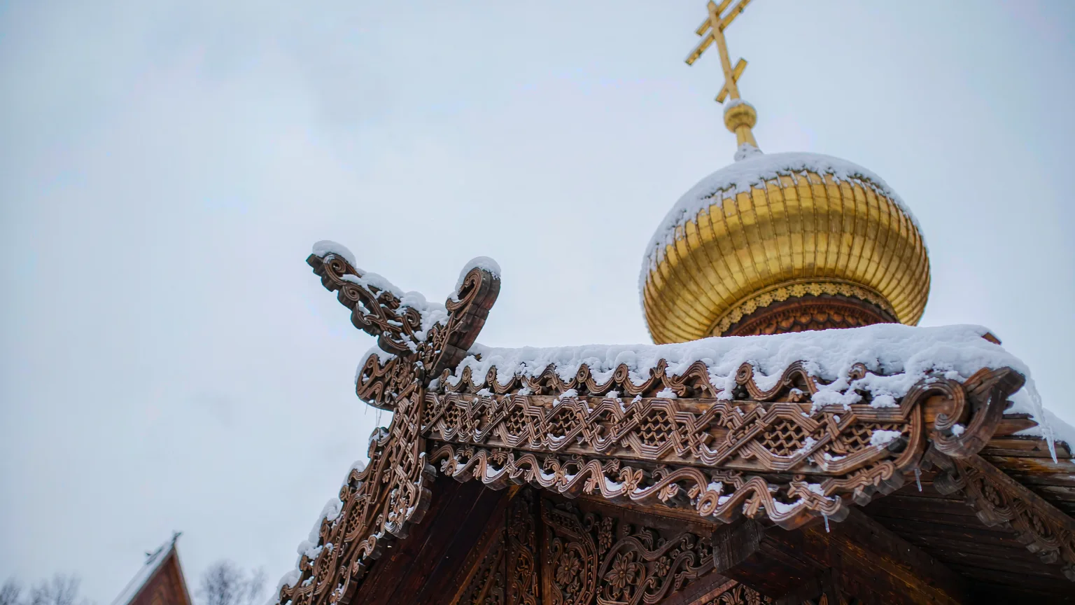 Close-up of ornate wooden carvings and snow on St. Nicholas Church dome