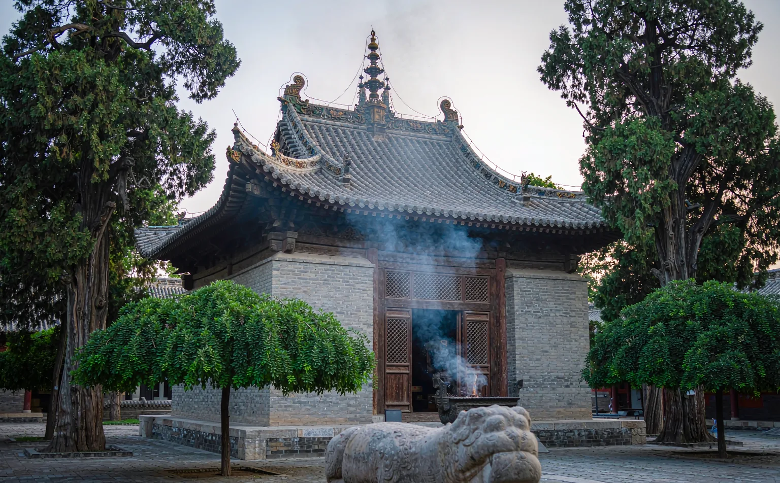 Incense smoke curling past the main hall of Wenshu Monastery